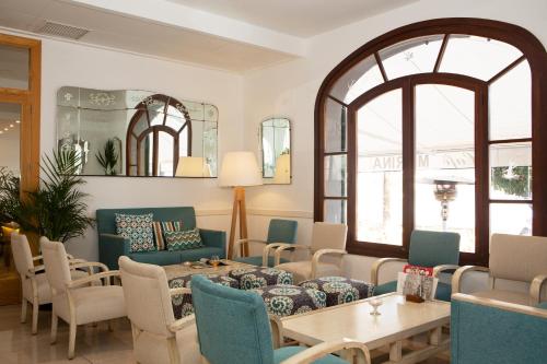 a living room with a table and chairs at Hotel Marina in Port de Soller