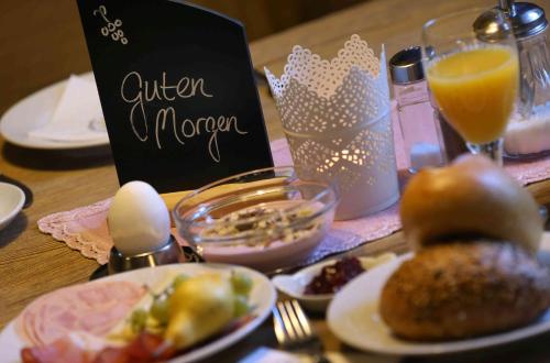 ein Holztisch mit Tellern voller Essen und einem Schild in der Unterkunft Gasthof Hotel Weinbau "Zum Goldenen Ochsen" in Sommerhausen
