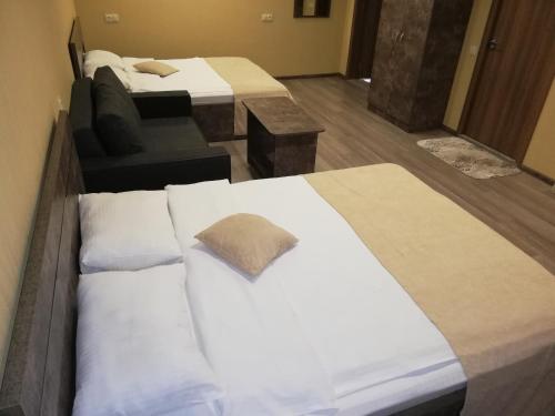 a hotel room with two beds and a couch at Hotel Nabadi in Tbilisi City