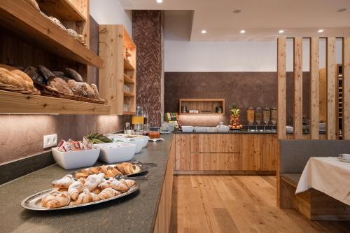 a kitchen with a counter with bread and pastries at Hotel Madatsch in Trafoi
