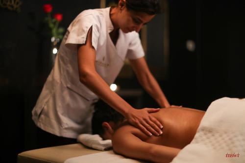 a woman giving a woman a back massage at Miramar Hotel Resort and Spa in Trâblous