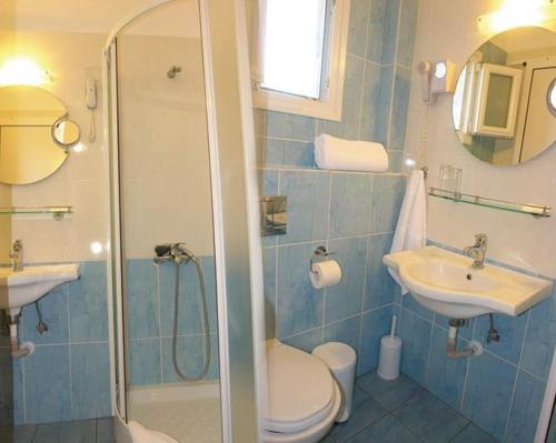 uma casa de banho com um chuveiro, um WC e um lavatório. em Hotel Afroditi em Paralia Panteleimonos