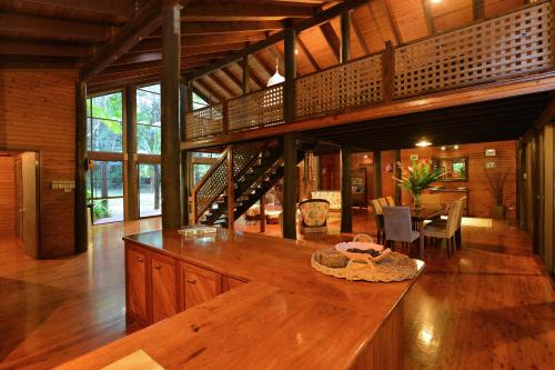 a large room with a wooden floor and a dining room at Wait-a-While Eco Retreat in Cow Bay