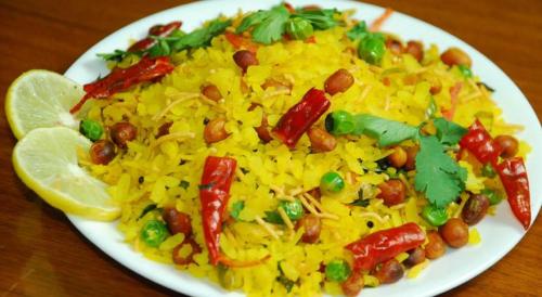 un piatto di riso con fagioli e verdure su un tavolo di Hotel Royal King by Sky Stays a Ahmedabad