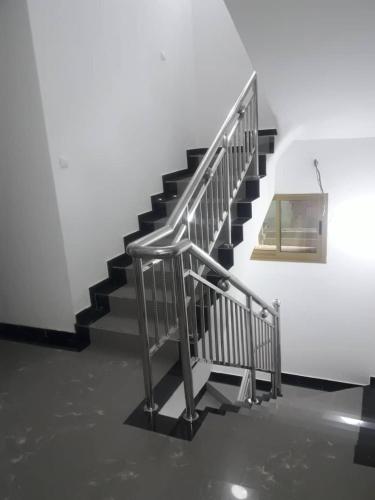 a metal staircase in a building with a picture on the wall at Hôtel La Couronne RW in Yaoundé