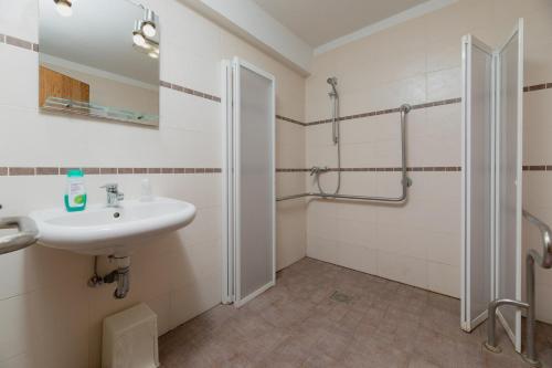 a bathroom with a sink and a shower at Motel D'ornex in Ornex
