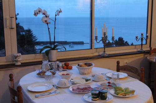 stół z talerzami jedzenia i widokiem na ocean w obiekcie Residence Beau Rivage Brehec w mieście Plouha