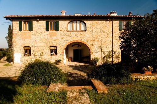 a large brick house with an archway in front of it at Podere Scaluccia in Impruneta