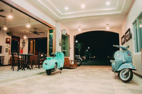 two blue scooters are parked in a room at Baan Kiang Wang in Phetchaburi