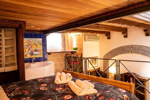 - une chambre avec une baignoire et un lit avec des chaussons dans l'établissement Suite Piazza del Gesù By DomusExtra, à Naples