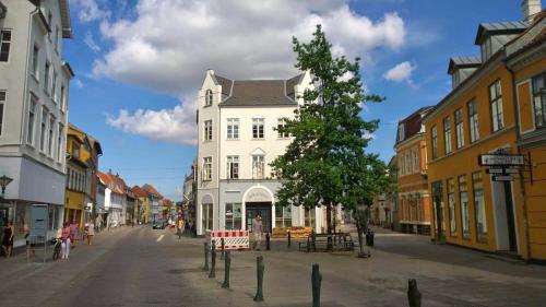a white building on the side of a street at City Hotel Apartments in Odense