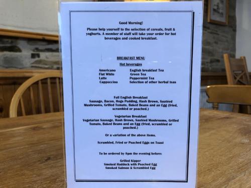 a menu for a restaurant on a sign on a table at The Galleon Inn in Fowey