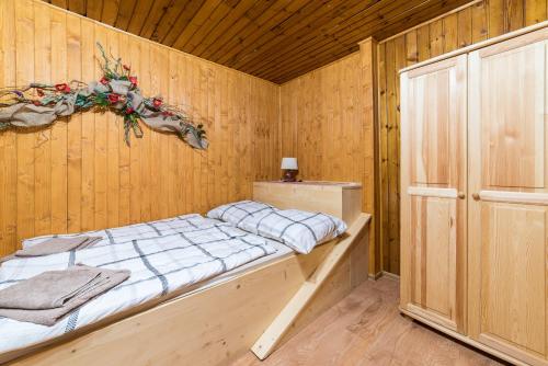 um quarto com uma cama num quarto de madeira em Apartmány Nízke Tatry - Krpáčovo em Dolná Lehota