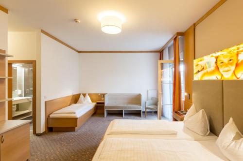 a hotel room with two beds and a couch at Thermenhotel Kurz in Lutzmannsburg