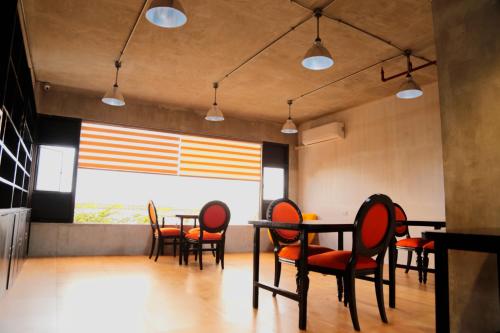 Travelbee Seaside Inn في تاغبيلاران سيتي: غرفة طعام بها طاولات وكراسي ونافذة كبيرة