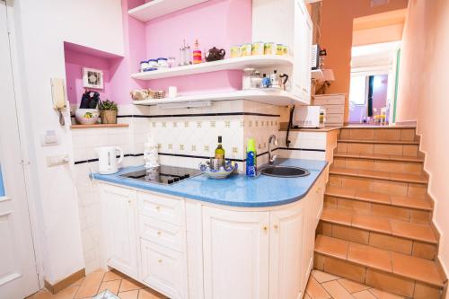 uma cozinha com paredes cor-de-rosa e brancas e um lavatório. em Casa Tonia San Cesareo em Sorrento