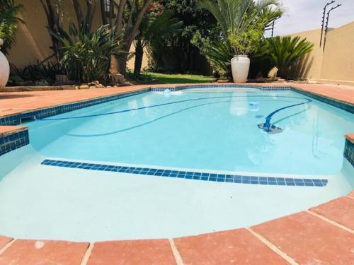 a large blue swimming pool in a yard at LilyRose Bed & Breakfast in Pretoria