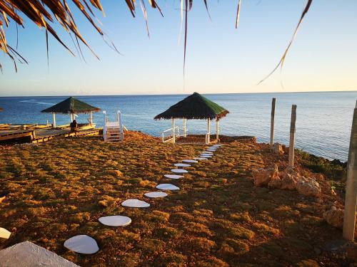 a pathway with umbrellas and chairs on a beach at Eastern Garan Hen Yuan Resort in Siquijor