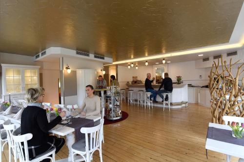 a group of people sitting at a table in a room at LAT Hotel & Apartmenthaus Berlin in Eisenhüttenstadt
