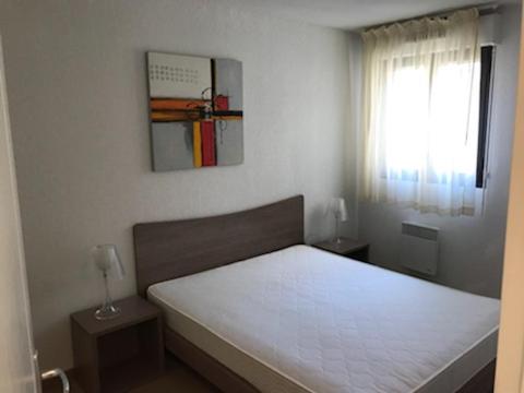 1 dormitorio con 1 cama blanca y ventana en LE VALDAZUR 5 Avenue Saint-Bernard, en Valberg