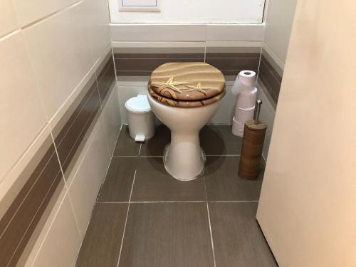y baño con aseo y asiento de madera. en Dave Apartman, en Szeged