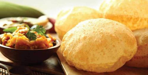a group of bread rolls with a bowl of food at Hotel International Inn - Near Delhi Airport in New Delhi