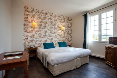 a hotel room with a large bed with blue pillows at Hôtel Restaurant Plaisance-Piscine couverte et chauffée- Proche Sarlat- in Vitrac