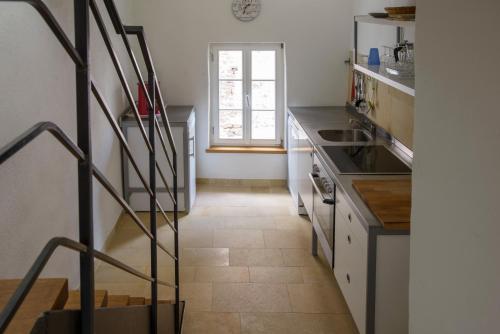 a kitchen with a staircase leading up to a window at Nengshof Ferienhaus Gänseblümchen in Wißmannsdorf