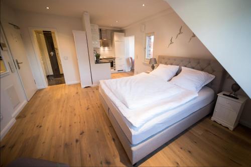 a bedroom with a large bed with white sheets at Abendsonne in Westerland
