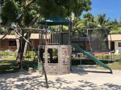 a playground with a slide in a park at La Playa Estrella Beach Resort in Bantayan Island