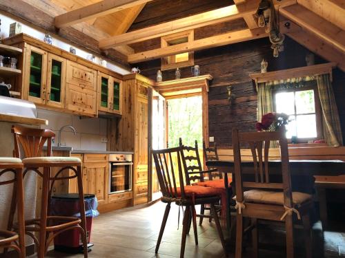 una cocina con armarios de madera, mesa y sillas en Waldheimathütte, en Sankt Kathrein am Hauenstein