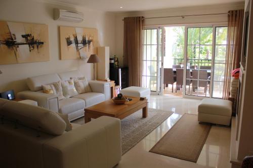 a living room with white couches and a table at Luxury 3 Bedroom Apartment on Gated Complex in Quarteira