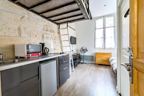 una cocina con fregadero y microondas en Studios entre le Pont d' Avignon et le Palais des Papes, en Aviñón
