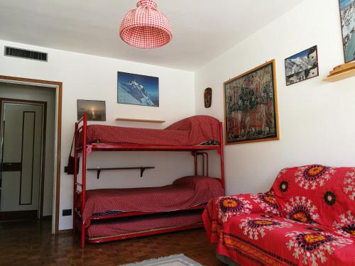 a bedroom with two bunk beds and a couch at L'Atelier du Temps - Appartamento CIRCE in Courmayeur