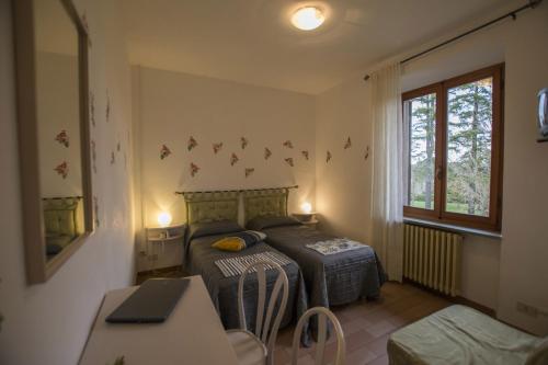 una camera con letto, tavolo e finestra di Albergo Ristorante Da Vestro a Monticiano