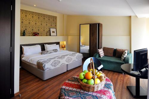 a hotel room with a bed and a basket of fruit at Tekla Palace By Urban Hotels in Tbilisi City