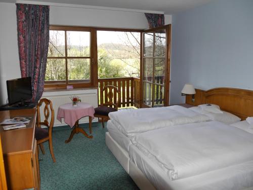 a hotel room with two beds and a balcony at Hotel und Gutsgaststätte Rappenhof in Weinsberg