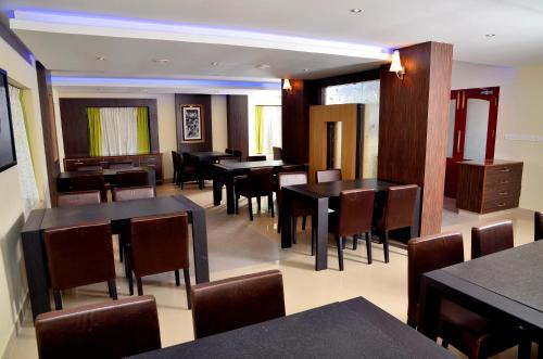 a dining room with black tables and chairs at French Avenue in Kallāyi