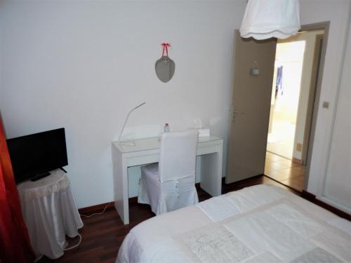 - une chambre avec un bureau, un lit et une télévision dans l'établissement Villa De Guénifey, à Josse