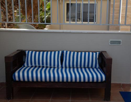 un divano a righe blu e bianche, seduto in una stanza di Motel Aviv a Eilat
