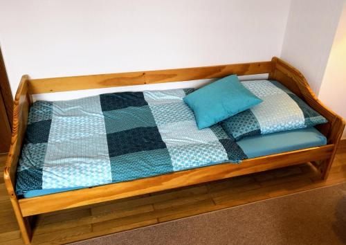 a wooden bed with a quilt and two pillows on it at Ferienwohnung Maria Laach 2 in Glees