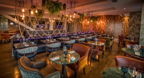 a restaurant with a row of tables and chairs at The Quay Hotel and Spa in Conwy