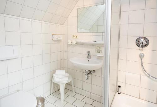 een witte badkamer met een wastafel en een toilet bij Hotel Müritzlicht in Waren