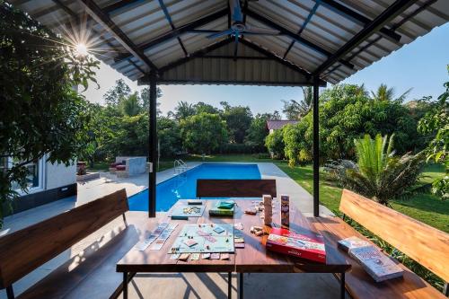 an outdoor patio with a table and a pool at SaffronStays Casa Manga, Karjat - pet-friendly pool villa near ND's Film World and Saltt in Karjat