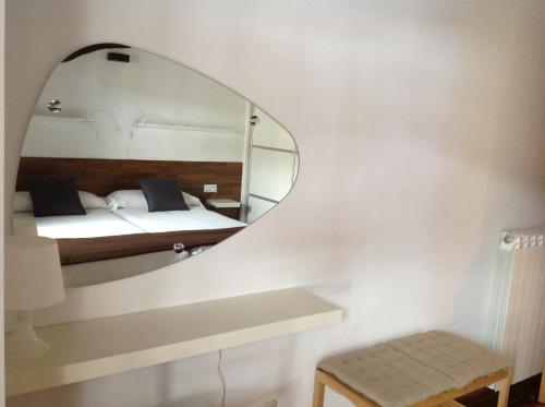 a bedroom with a mirror and a bed at Apartamentos Turísticos Rincones del Vino in Ezcaray