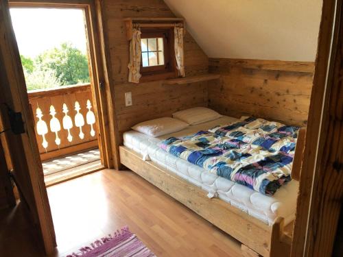 a bedroom with a bed in a room with a window at Waldheimathütte in Sankt Kathrein am Hauenstein