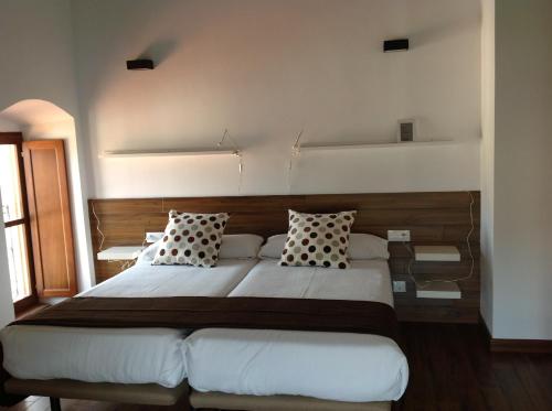a bedroom with a large bed with two pillows at Apartamentos Turísticos Rincones del Vino in Ezcaray