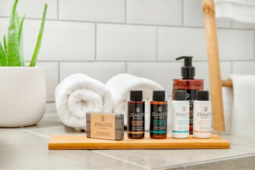 a wooden tray with four bottles of products on a counter at Maryflower Premium Apartments Piraeus in Piraeus