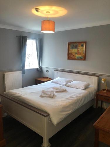 a bedroom with a white bed with two towels on it at The Crown Hotel in Ryde