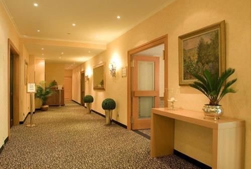 a hallway of a building with a plant on a table at Parkhotel am Taunus in Oberursel